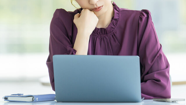 パソコンを使いながら考える女性・ビジネスウーマン, Businesswoman Thinking While Using a Laptop
