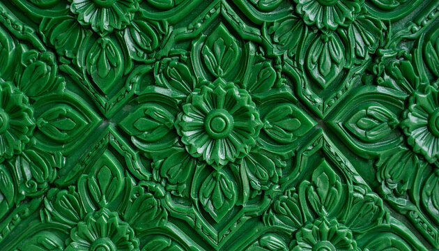 an interior wall adorned with a decorative moulding. the moulding has a greenish hue and is characterized by intricate floral patterns