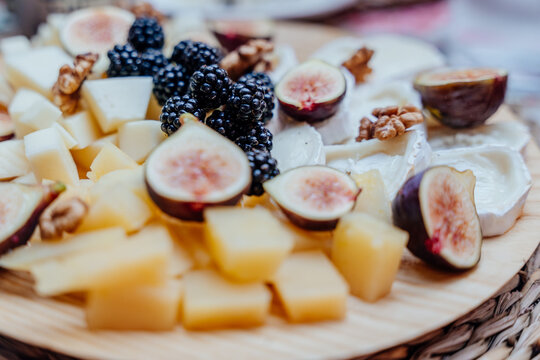 Gourmet cheese board with fresh figs, blackberries and walnuts for Mediterranean summer gathering