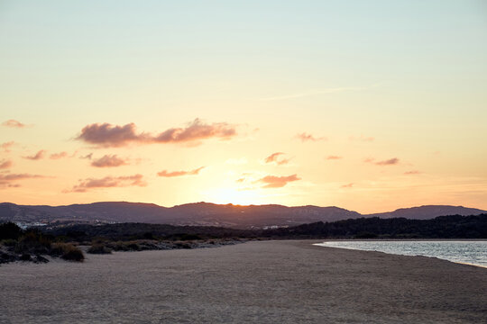 Scenic sunset over coastal mountains and sandy beach