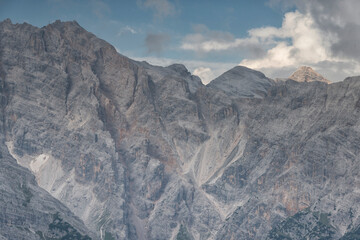 Majestic limestone mountain peaks stand tall under moody storm clouds in an alpine wilderness, ideal for travel, adventure, and outdoor nature themes. © marcodenaro