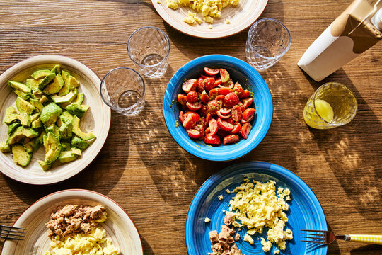 Healthy Breakfast Table with Scrambled Eggs, Avocado, Cherry Tomatoes and Tuna