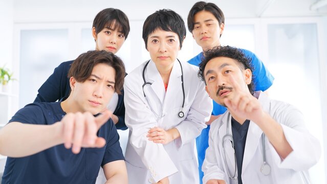 難しい表情でカメラを見つめる医師と看護師の医療チーム