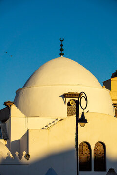 Close-up view of a mosque's white dome with crescent finial and arched window grilles, North Africa, Algiers, Algeria