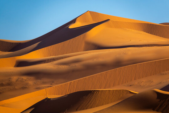 Dramatic light and shadow on sand dune ridges in the Sahara desert, Tassili N'Ajjer National Park, Tadrart Rouge, Algeria