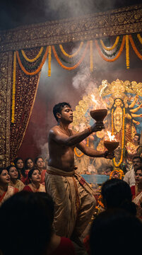 Shirtless man in traditional dhoti performing spiritual fire dance holding burning clay pots with smoke before audience, suitable for mobile phone wallpaper.