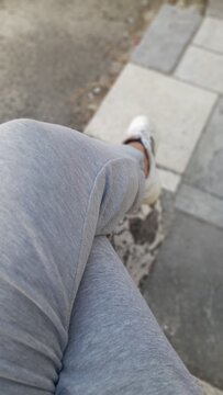 Close-up od a person in gray sweatpants relaxing outdoors