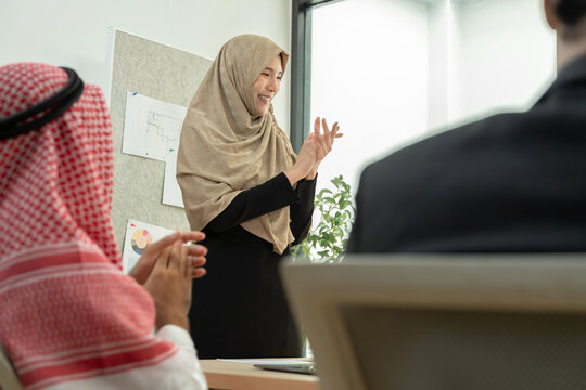 Muslim businesswoman presenting to colleagues in office