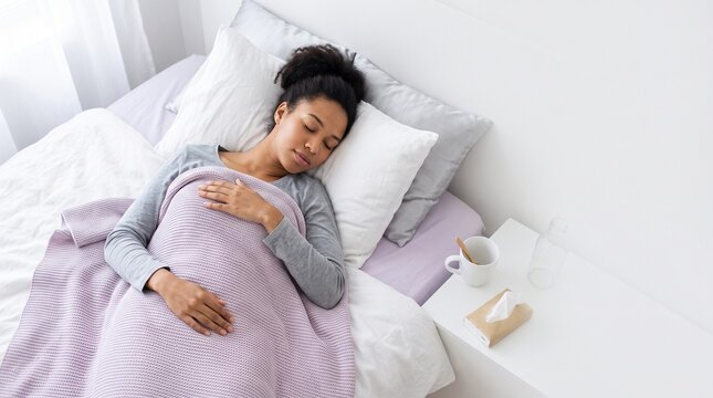 Sick woman resting in bed with blanket and pillow  