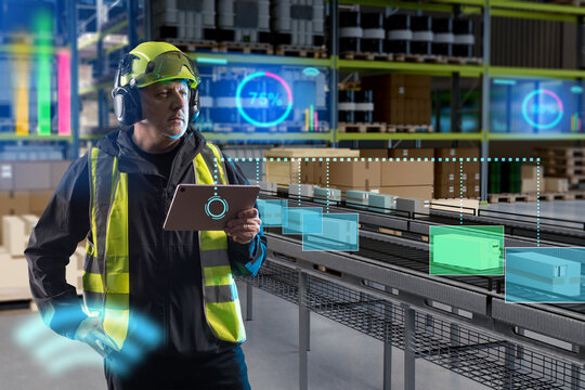Warehouse automation. Logistics worker monitors automated parcel sorting and conveyor operations with a tablet for inventory control and order processing.