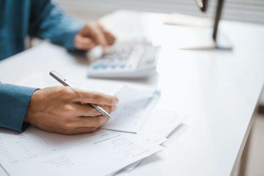 A hand marks papers as invoice verification supports accounting for payment and financial figures, while invoice details guide verification through accounting of payment and financial records nearby.