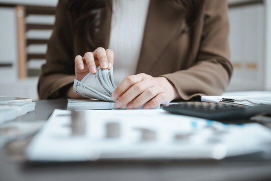 A woman counts banknotes beside paperwork as cash guides flow for management through financial strategy, while cash notes trace flow for management and financial choices within strategy at the table.