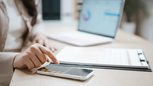 A woman checks a phone above papers as marketing analytics guide digital campaign performance, while marketing figures support analytics through digital campaign checks and performance on the screen.