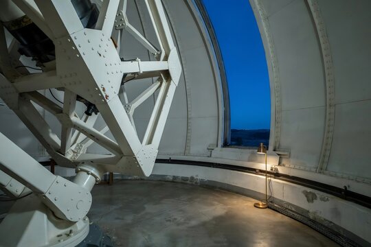 Steel truss of an observatory telescope framed by the open dome slit &ndash; Great for astrophysics articles, engineering promotion, or educational media.