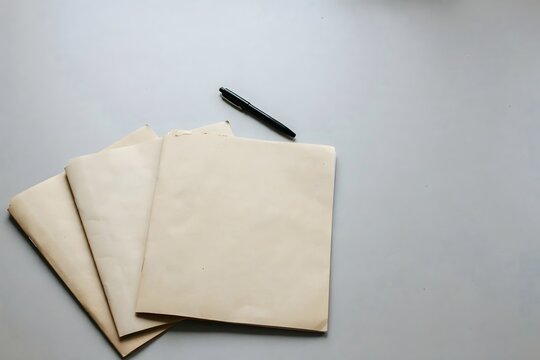 Three plain kraft folders fanned out beside a black pen &ndash; Ideal for document templates, office mockups, or admin branding.