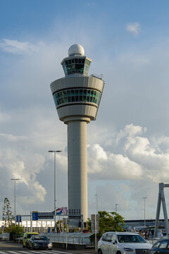 August 21, 2026, Amsterdam, Netherlands - Air traffic control tower at Schiphol Airport with cars and people
