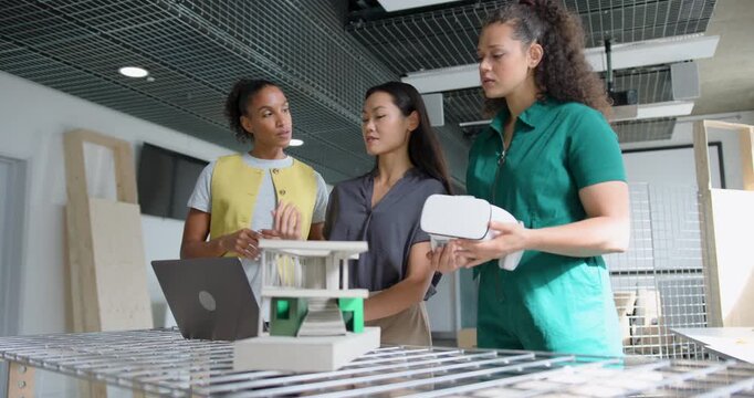 Three Female Design Professionals Working on Project Together, using Laptop and VR headset