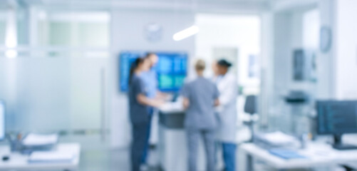 Fototapeta premium A blurred image of healthcare professionals discussing patient information in a modern hospital environment, showcasing teamwork and collaboration.