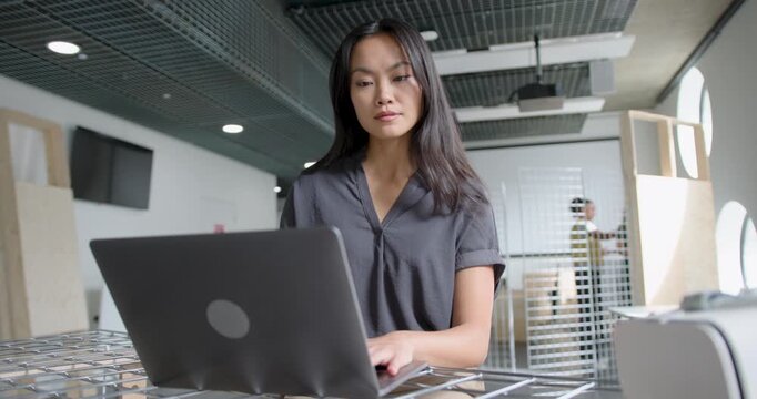 Woman Focusing on Laptop in Modern Open plan Workspace