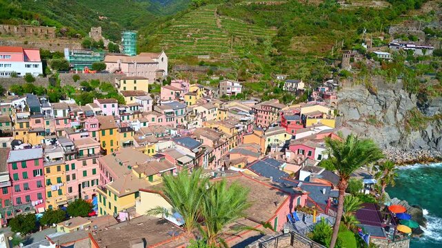 Colorful coastal village revealed by aerial sweep over cliffside in cinque terre. Vernazza, Italy