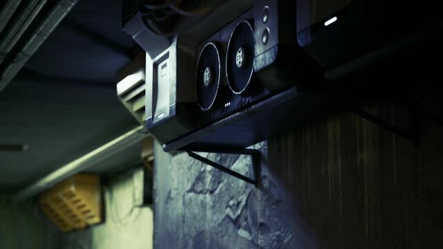 Detailed industrial fan assembly in tight frame, motor housing, mounting brackets and ventilation grille clearly visible with worn paint and surface grime,