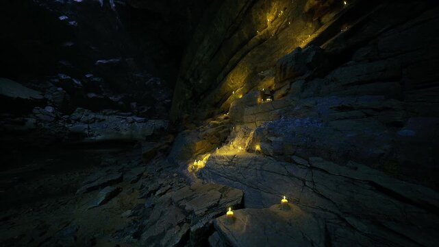 Lantern cascade along cavern wall glow, clustered beacons spill warm light across textured stone, vertical stream of votive fire, still mood