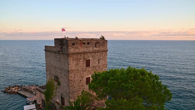 Historic stone watchtower overlooking mediterranean sea at sunset. Monterosso al Mare, Italy