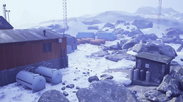 rustic coastal outpost with snow covered sheds and propane tanks, rocky shoreline under muted blue light, weathered storage structures and driftwood on pebble