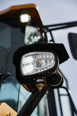 Construction machine headlamp with multiple LED elements and horn mounted beside the cab, illustrating work vehicle lighting hardware and operator visibility equipment © K