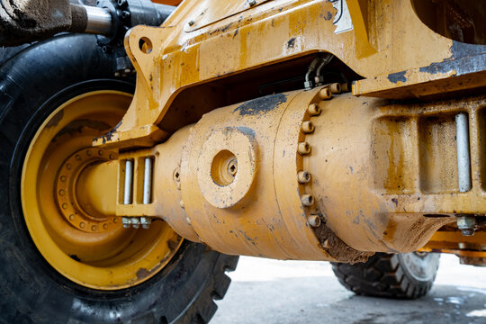 Heavy construction machine axle with differential housing, bolted casing and large wheel hub, representing drivetrain components and mechanical maintenance access