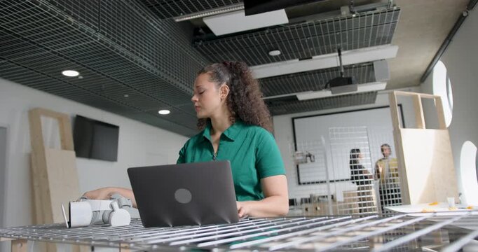 Female Engineer Working on Laptop and VR headset in Modern Office