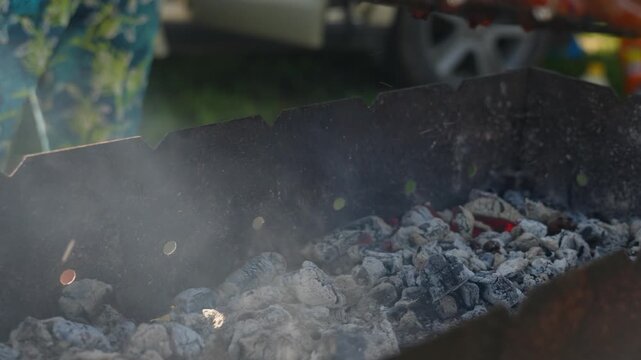Ribs are grilling on the grate, and a person flips the grate over.