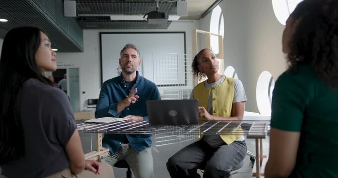 Team Discussing and Collaborating in Business Meeting Around a Table in Modern Office