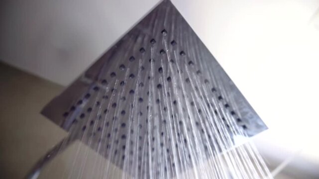 Water Flowing From Square Metal Overhead Shower Head. Modern Bathroom Plumbing Equipment. Daily Body Hygiene 