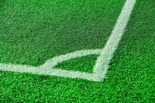 Abstract sport background. Corner of soccer, football field with bright green artificial grass and white markings