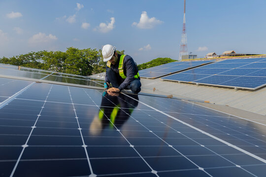 Engineer service check installation solar cell on the roof of factory. Engineers walking on roof inspect and check solar cell panel. Engineer working inspection installation solar cell on the roof