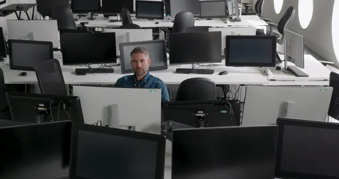 One Mature Male IT Professional in Empty Modern Office working with Technology