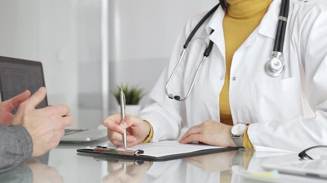 Doctor writing prescription during patient consultation in clinic, providing medical care and diagnosis. Medicine, healthcare and science concept