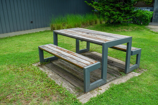 Wooden Bench in park,chairs and table in countryside,outdoor seating cafe or restaurant,Neat paved patio with sitting area,small garden in farm.