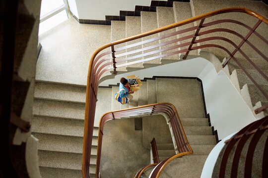 Woman climbs up the stairs inside the multi-story building