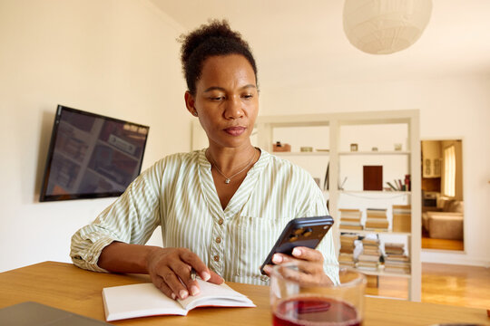 Woman works from home, checks her mobile phone