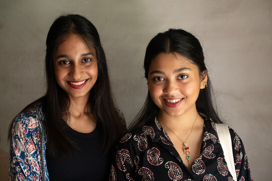 Two cheerful and happy young woman portrait looking at camera