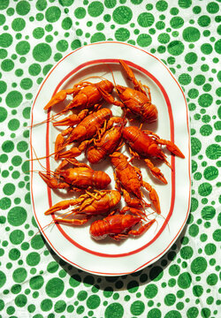 Crawfish served on a plate with a green patterned tablecloth