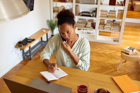 Woman works from home, placing a phone call