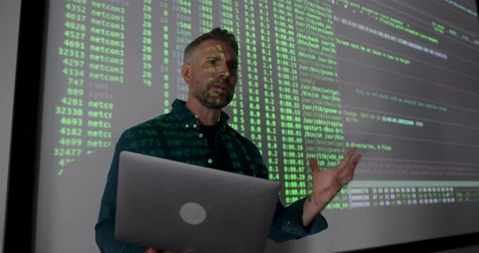 Mature Male Technology Expert Presenting Data Analysis on Screen, using Laptop