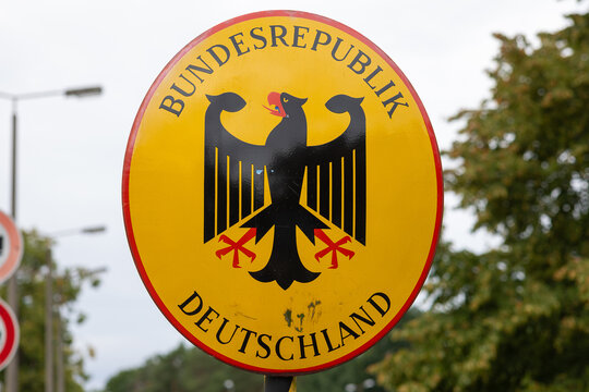 Ein rundes Hoheitsschild der Bundesrepublik Deutschland mit Bundesadler markiert den Grenz&uuml;bergang 