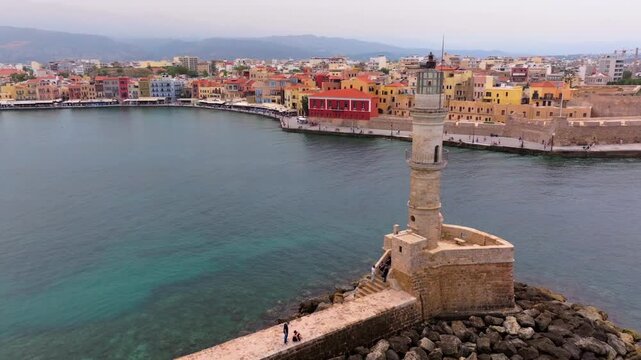  View of Chania with the amazing lighthouse, mosque, venetian shipyards, Crete, Greece.Waves crashing on lighthouse, Beautiful Greece and best scenic places - panorama