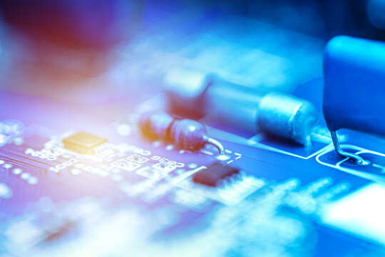 Close-up of an electronic resistor mounted on a circuit board with soft focus and glowing light effects. Electronics engineering and technology concept.