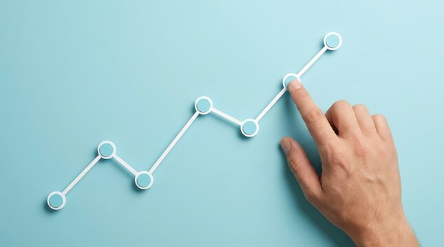 Hand touches upward trending line graph composed of dots and lines on light blue background, signifying positive growth and development.