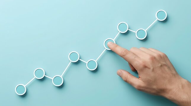 Person's finger touching data point on upward trending line graph on light blue background with white dots and lines, representing growth and progress in business.